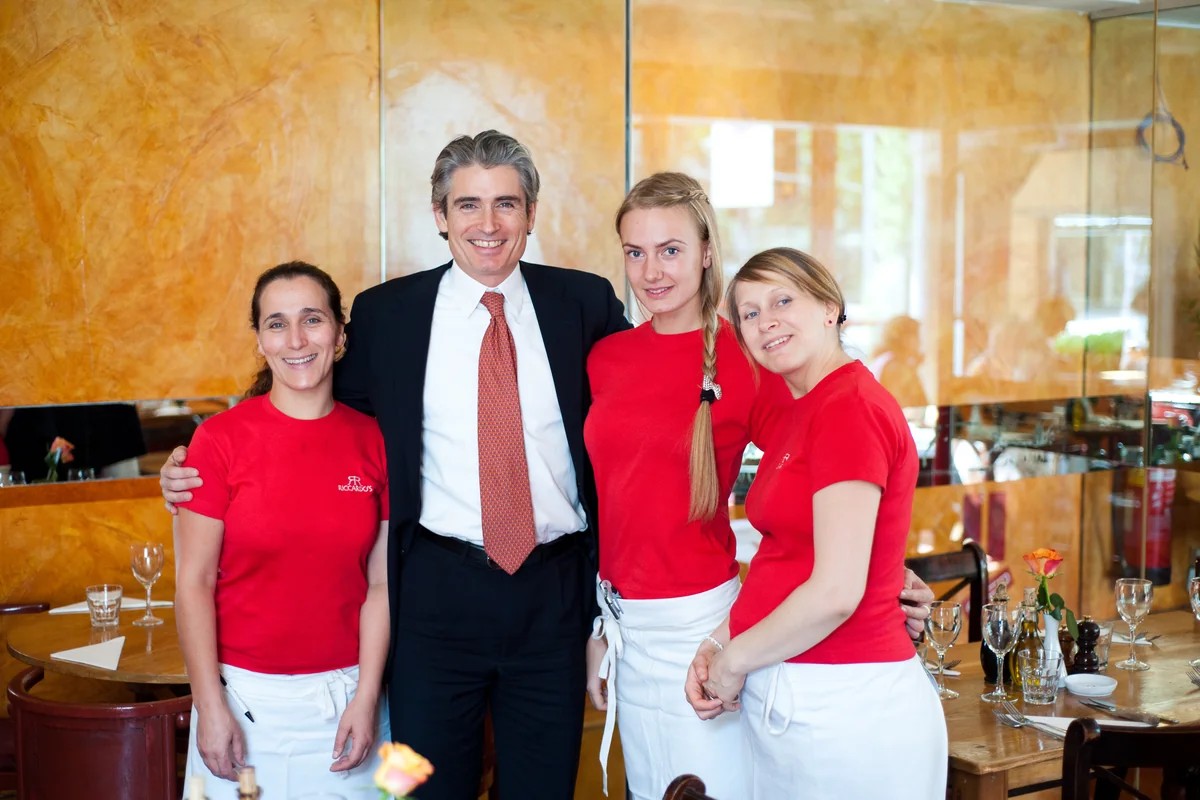 Riccardo Mariti with three members of his team in the dining room at Riccardo's, Chelsea, standing together between laid tables