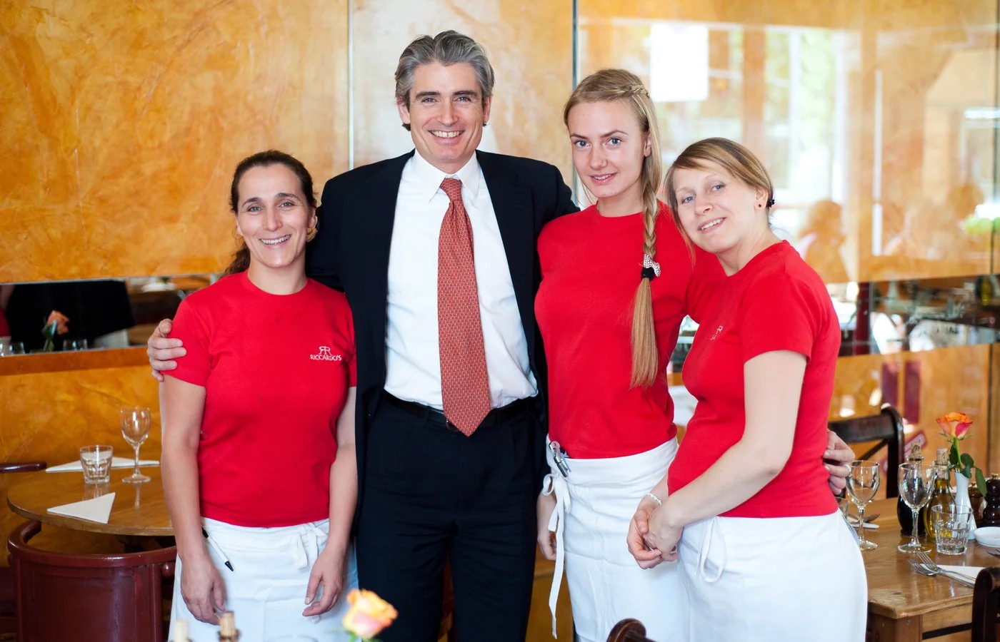 Riccardo Mariti with three members of his team in the dining room at Riccardo's, Chelsea, standing together between laid tables